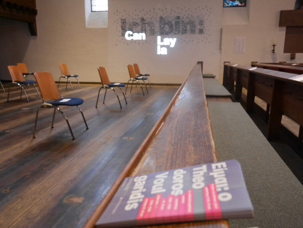 Bild, Postkarten Ich bin: Theodoros Boulgarides, im Hintergrund die Installation