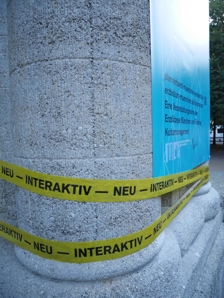 Bild, Laborarium, Flatterbänder, Interaktiv – neu, an einer Säule am Kirchenportal